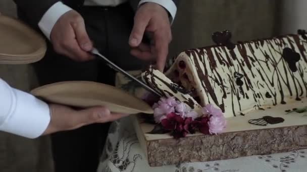 Primer plano de la torta de boda triangular original. La novia y el novio cortaron el pastel en pedazos para sus invitados. Tradición de boda — Vídeo de stock