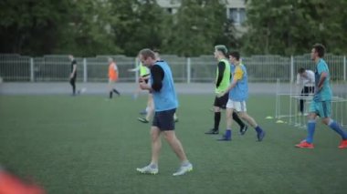 Minsk, Belarus - 23 Haziran 2020: Futbol sahasında hızlı koştuktan sonra antrenman yapan futbolcular yavaşça ter silerler. Yandan bak. Yakın plan.