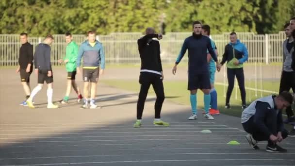 Minsk, Bielorrusia - 23 de junio de 2020: Entrenamiento por equipos de fútbol. Los jugadores hacen ejercicios de pares para estirar las piernas. Un primer plano. Fondo delantero borroso — Vídeos de Stock