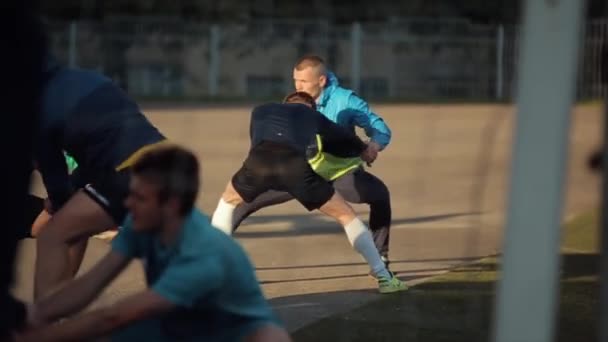 白俄罗斯明斯克- 2020年6月23日：足球队训练。玩家在伸展腿时做对练习。特写A close -up.模糊的前缘背景 — 图库视频影像