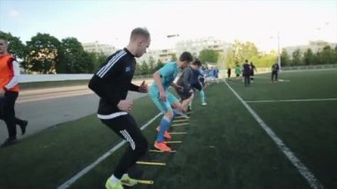 Şehirdeki futbol sahasında futbol oyuncularının yoğun eğitimi. Yan görüş. Yakın plan. Model Gerçekleştirildi