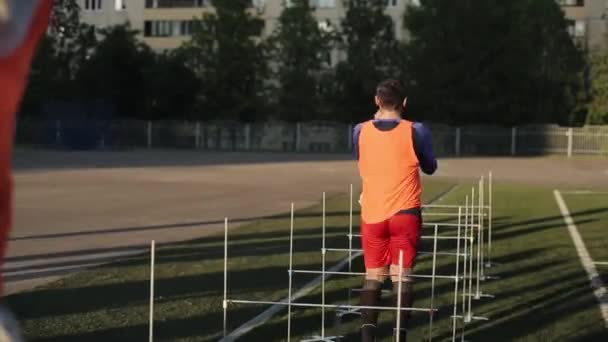 Minsk, Bielorussia - 23 giugno 2020: allenamento della squadra di calcio. Primo piano delle gambe giocatori di calcio saltare le barriere in mezzo al sole tramontante — Video Stock