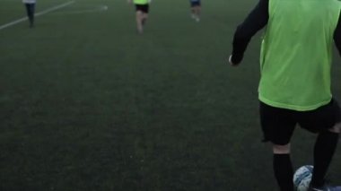 Futbol oyuncularının yakın çekimleri koçun gözetiminde antrenmanlarda birbirlerine futbol topu paslıyor.