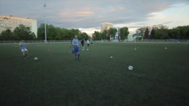 Futbol kulübü eğitimi. Oyuncular futbol sahasında bir oyun anı çalışırlar. Yakın plan.