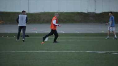 Şehir stadyumunda futbol takımı antrenmanı. Oyuncular kalede atış talimi yapıyorlar. Yakın plan.