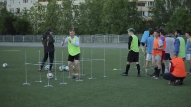 Bir futbol kulübü antrenmanında oyuncular futbol sahasında antrenman yapar top sürme ve şut atma antrenmanı yapar. Yakın plan. Model Gerçekleştirildi