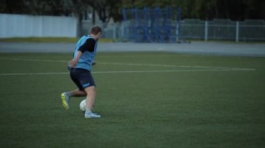 Bir futbol kulübü antrenmanında oyuncular futbol sahasında antrenman yapar top sürme ve şut atma antrenmanı yapar. Yakın plan.