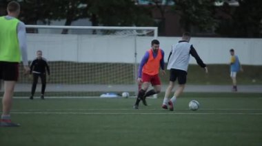 Futbolcular futbol sahasında antrenman yapıyor ve kaleye vuruyor. Yakın plan.