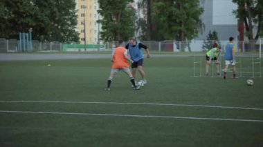 Futbol takımları oyun antrenmanı. Futbolcu kaleye savunmacıların etrafında topla gider ve kaleyi vurur. Yakın plan.