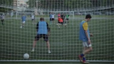 Futbol kulübü eğitimi. Kamera hücum anında ve gol anında kapının arkasından ağdan ateş eder. Yakın plan.
