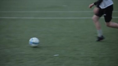 Futbol takımları oyun antrenmanı. Futbolcu kaleye savunmacıların etrafında topla gider ve kaleyi vurur. Yakın plan.