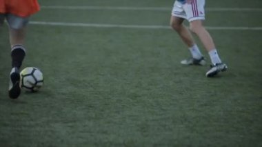 Futbol takımının oyuncuları kapılara doğru koşuyorlar birbirlerine pas veriyorlar ve çok güzel bir gol atıyorlar. Yakın plan.