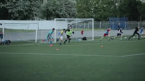 Los jugadores del club de fútbol corren a velocidad en el campo de fútbol en el entrenamiento. Vista desde un lado. Primer plano — Vídeos de Stock