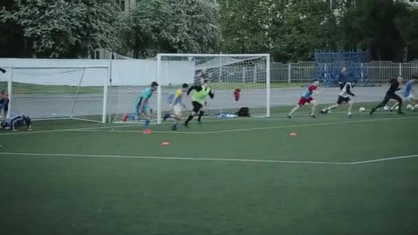 Los jugadores del club de fútbol corren a velocidad en el campo de fútbol en el entrenamiento. Vista desde un lado. Primer plano — Vídeo de stock