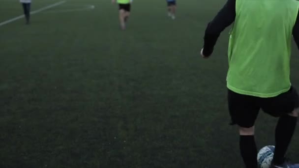 Primer plano de los jugadores de fútbol que pasan los balones de fútbol entre sí en el entrenamiento bajo la supervisión del entrenador — Vídeo de stock