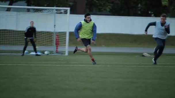 Allenamento della squadra di calcio. Un primo piano delle gambe dei giocatori che saltano oltre la barriera e corrono attraverso il campo. Rallentatore — Video Stock