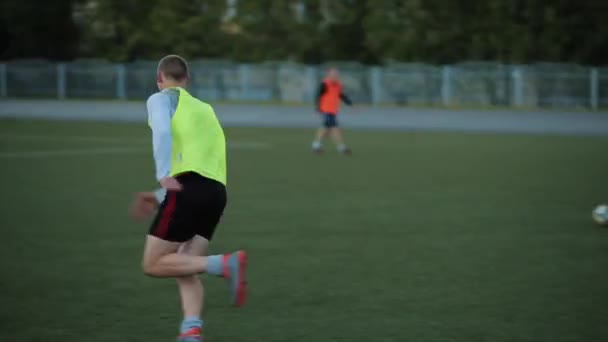 Futbol takımı eğitimi. Oyuncular bariyerlerin üzerinden atlayıp sahada topla koşan karmaşık hız egzersizleri yapıyorlar. Yakın plan. — Stok video