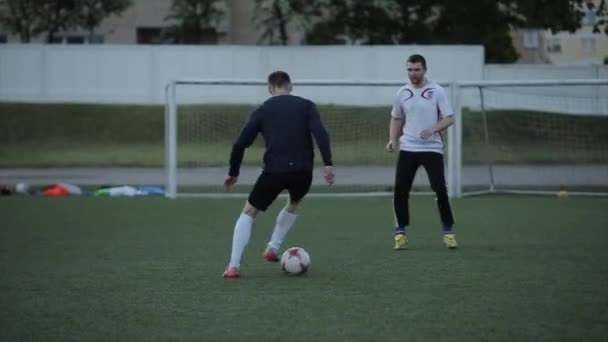 Los jugadores del equipo de fútbol durante el entrenamiento trabajan en momentos de juego en el campo y practican driblar. Primer plano — Vídeos de Stock