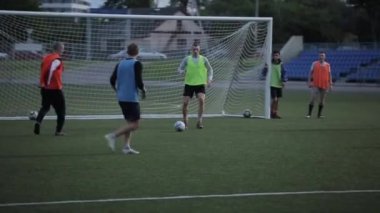 Futbol takımı eğitimi. Oyuncular sahada atak yapar ve gol atarlar. Yakın plan.