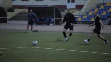 Futbol takımı eğitimi. Oyuncular sahada atak yapar ve gol atarlar. Yakın plan.