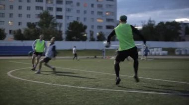 Futbol takımı eğitimi. Oyuncular bariyerlerin üzerinden atlayıp sahada topla koşan karmaşık hız egzersizleri yapıyorlar. Yakın plan.