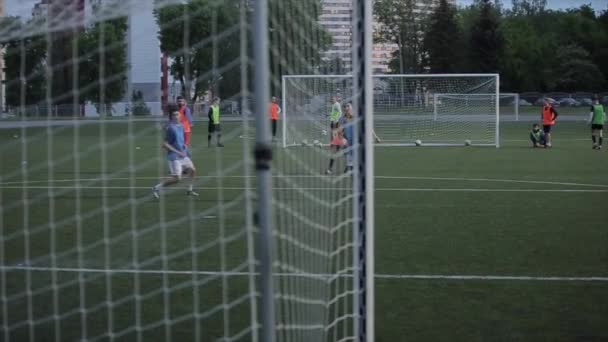 O momento do gol no treinamento da equipe de futebol. A disparar por detrás do portão através da rede. Close-up. Modelo realinhado — Vídeo de Stock