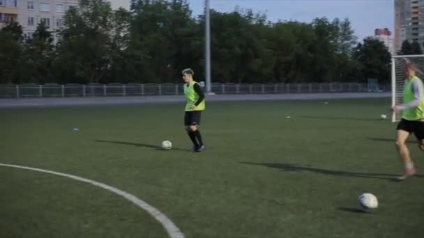 Vid träningen av fotbollsklubben spelarna passerar bollen till varandra och gör ett mål. Närbild. Kameran följer spelarna. Modell Realesed — Stockvideo