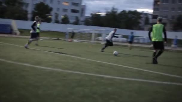 Het moment van het doelpunt bij de wedstrijdtraining van het voetbalteam tegen de achtergrond van de avondstad. Slow-motion. Close-up — Stockvideo