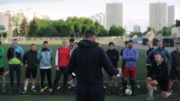 축구 클럽 선수들을 훈련시키는 것을 지시하는 코치의 뒤에서 가까운 거리에 있다. 모범이 실현되다. — 비디오