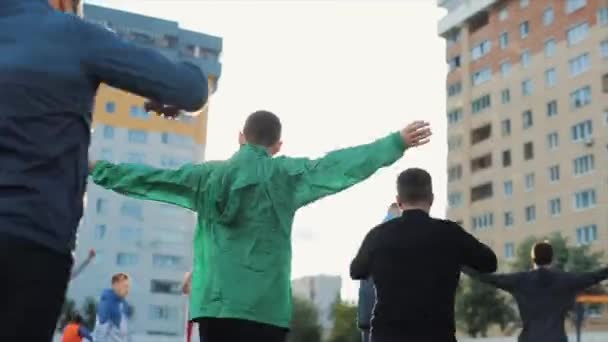 Réchauffement de l'équipe de football sur le terrain de sport de la ville contre le soleil couchant. Vue de l'arrière. Gros plan. Modèle Réalisé — Video