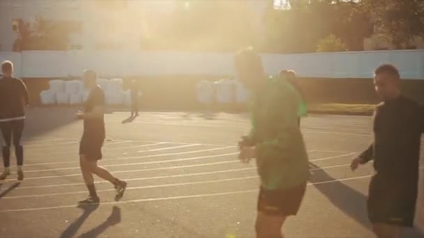 Futbol kulübünün antrenman süreci. Oyuncular güneşin batışında spor sahasında atlayışlar yaparlar. Yakın plan. Model Gerçekleştirildi — Stok video