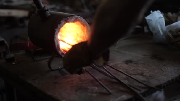 Close-up van de roodgloeiende ijzeren staaf die de smid uit het ovenvuur in de werkplaats haalde — Stockvideo