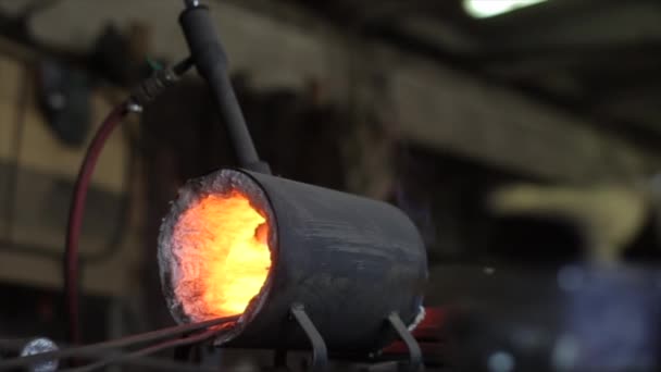 Close-up da cara quente do mestre de ferreiro no trabalho. Em primeiro plano está o fundo borrado de um forno de ferreiro em chamas — Vídeo de Stock