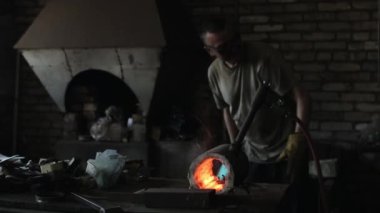 Karanlık bir ocakta yanan kompakt bir fırın ve bir çalışma ile ayarlanmış bir gaz kaynağı. Yakın plan.