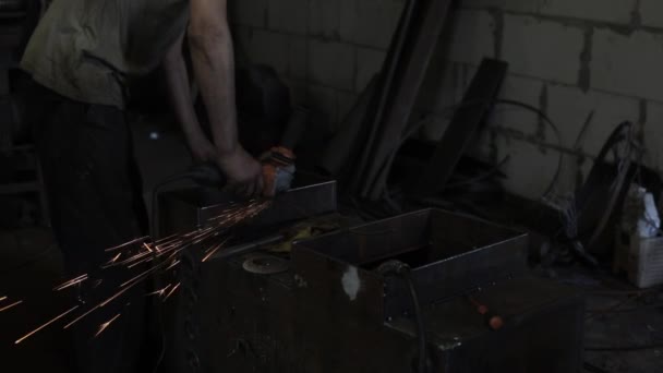 Чоловік подрібнює металеву частину електричним шліфувальним інструментом. Яскраві іскри вибухнули з-під інструменту. Крупним планом — стокове відео