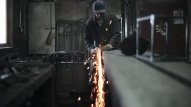 Étincelles lors du travail d'un outil de meulage électrique utilisé par un monteur de métal dans l'atelier. Vue de face — Video