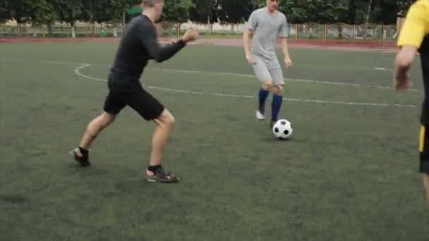 トレーニング中のサッカー選手はサッカー場で試合の瞬間を練習する。カメラはボールを追いかける。閉鎖 — ストック動画