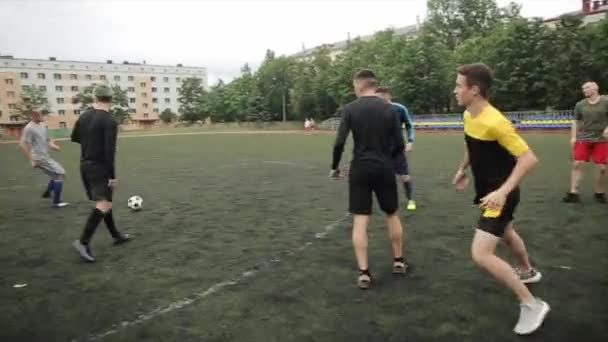 Antrenmandaki futbol takımının sporcuları şehir stadyumunda futbol oynuyorlar. Kamera topu seyrediyor. Yakın plan. — Stok video