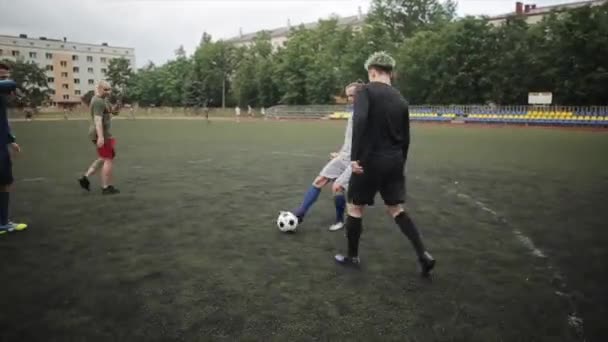 Équipe de football d'entraînement de jeu au stade de la ville par une journée d'été nuageuse. La caméra suit la balle. Gros plan — Video