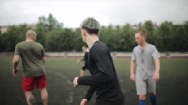 Los futbolistas en el entrenamiento entrenan momentos de juego en el campo de fútbol. La cámara sigue la pelota. Primer plano — Vídeos de Stock