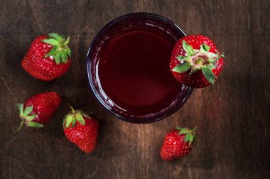 Koyu ahşap arka plan üzerinde çilek suyu