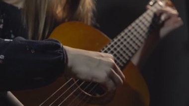 Kız oyun gitar. Stüdyo ışık. Koyu arka plan. Portre