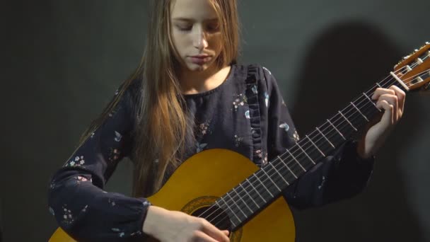 Chica Toca Guitarra Luz Del Estudio Fondo Oscuro — Vídeo de stock