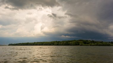 arka plan ile karanlık fırtına bulutları. Tuna'nın riverside adlı bir gök gürültüsü fırtına öncesi kara bulutlar.