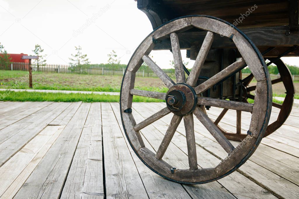 Wooden wheel of old cart close-up soft focus