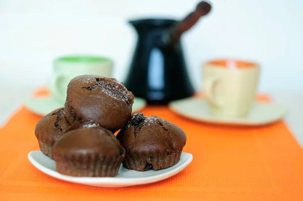 Magdalenas de chocolate dos tazas y turk con café . — Foto de Stock