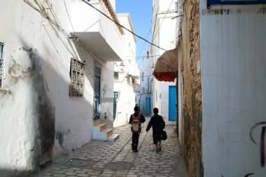 İki öğrenci Sousse eski şehir sokakta okula gitmek.