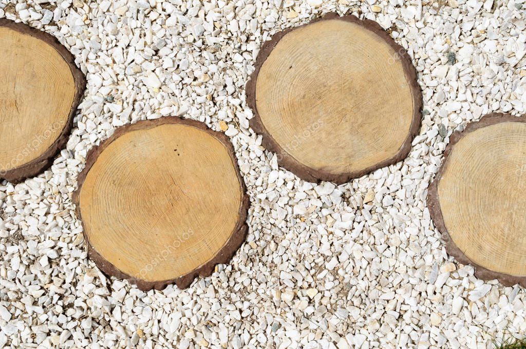 Light gravel and round cut logs background.