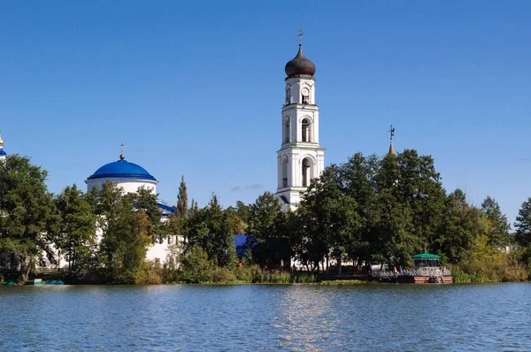 Uitzicht vanaf het meer naar de klokkentoren van het klooster van Raif, Rusland. — Stockfoto