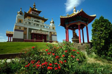 Mavi gökyüzünün arka planında bir Budist tapınağı ve bir çardak, Elista.